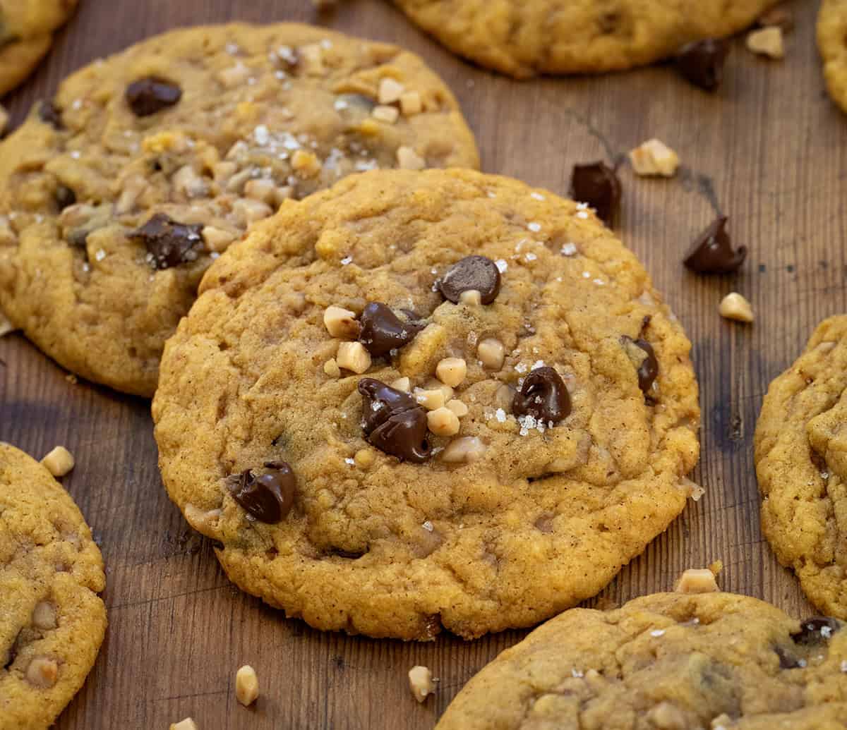 Close up of Pumpkin Toffee Chocolate Chip Cookies on a wooden table.