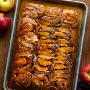Apple Caramel Rolls on a sheet pan on a wooden table from overhead.