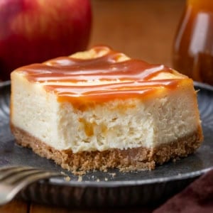 Piece of Apple Cider Cheesecake Bars on a plate with a bite removed.