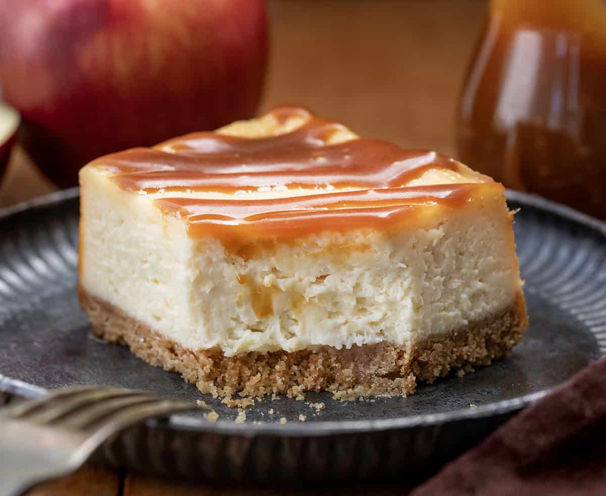 Piece of Apple Cider Cheesecake Bars on a plate with a bite removed.