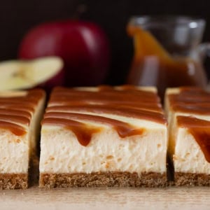 Cut Apple Cider Cheesecake Bars on a wooden table very close up.