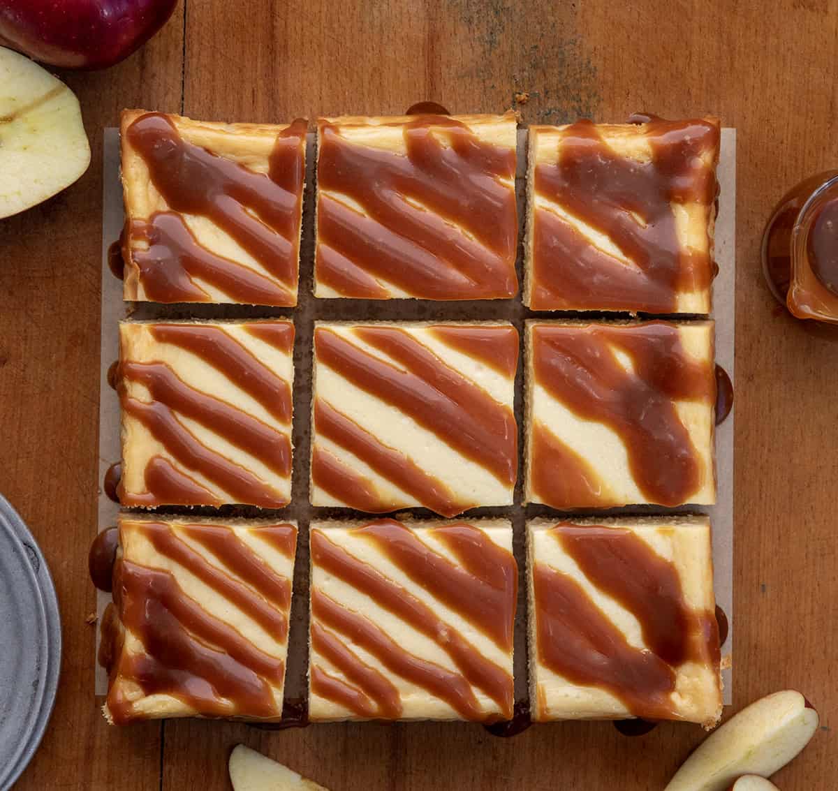 Apple Cider Cheesecake Bars cut into squares on a wooden table from overhead.