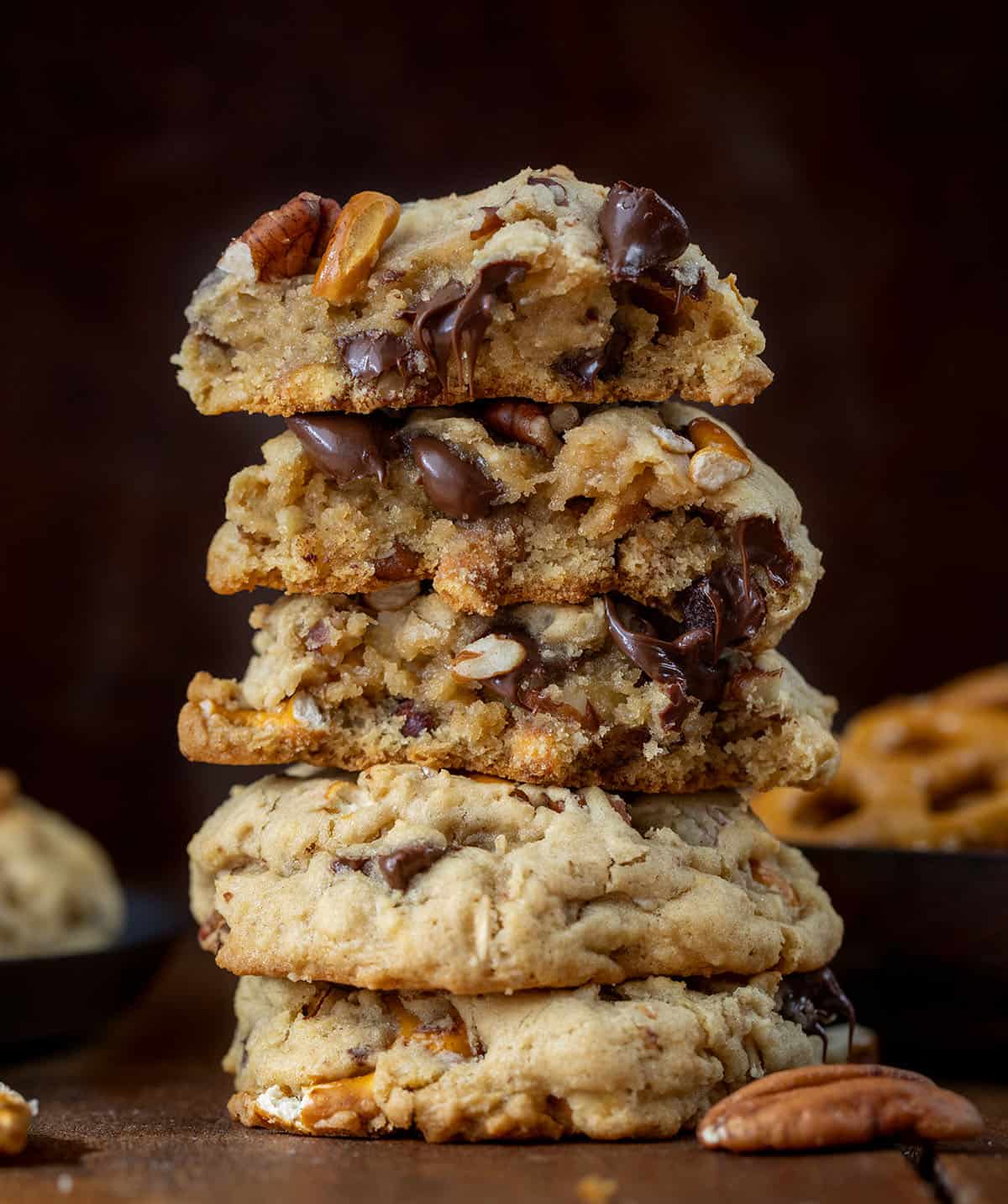 Stack of Brown Sugar Cowboy Cookies on a wooden table with more cookies around it.