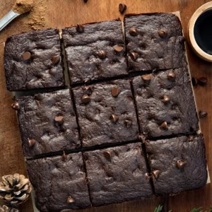 Chocolate Gingerbread Brownies cut into squares on a wooden table from overhead.