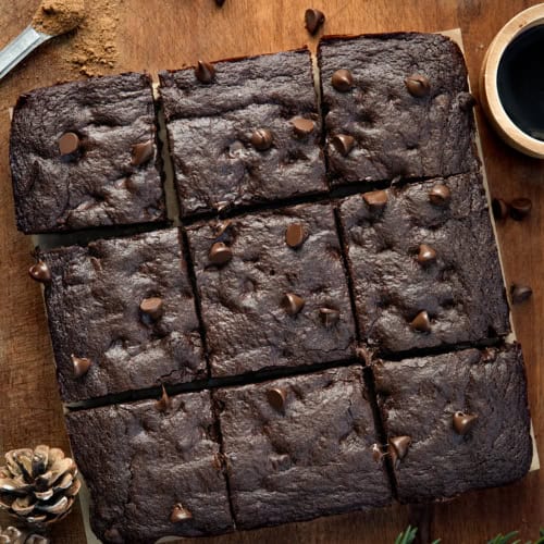 Chocolate Gingerbread Brownies cut into squares on a wooden table from overhead.