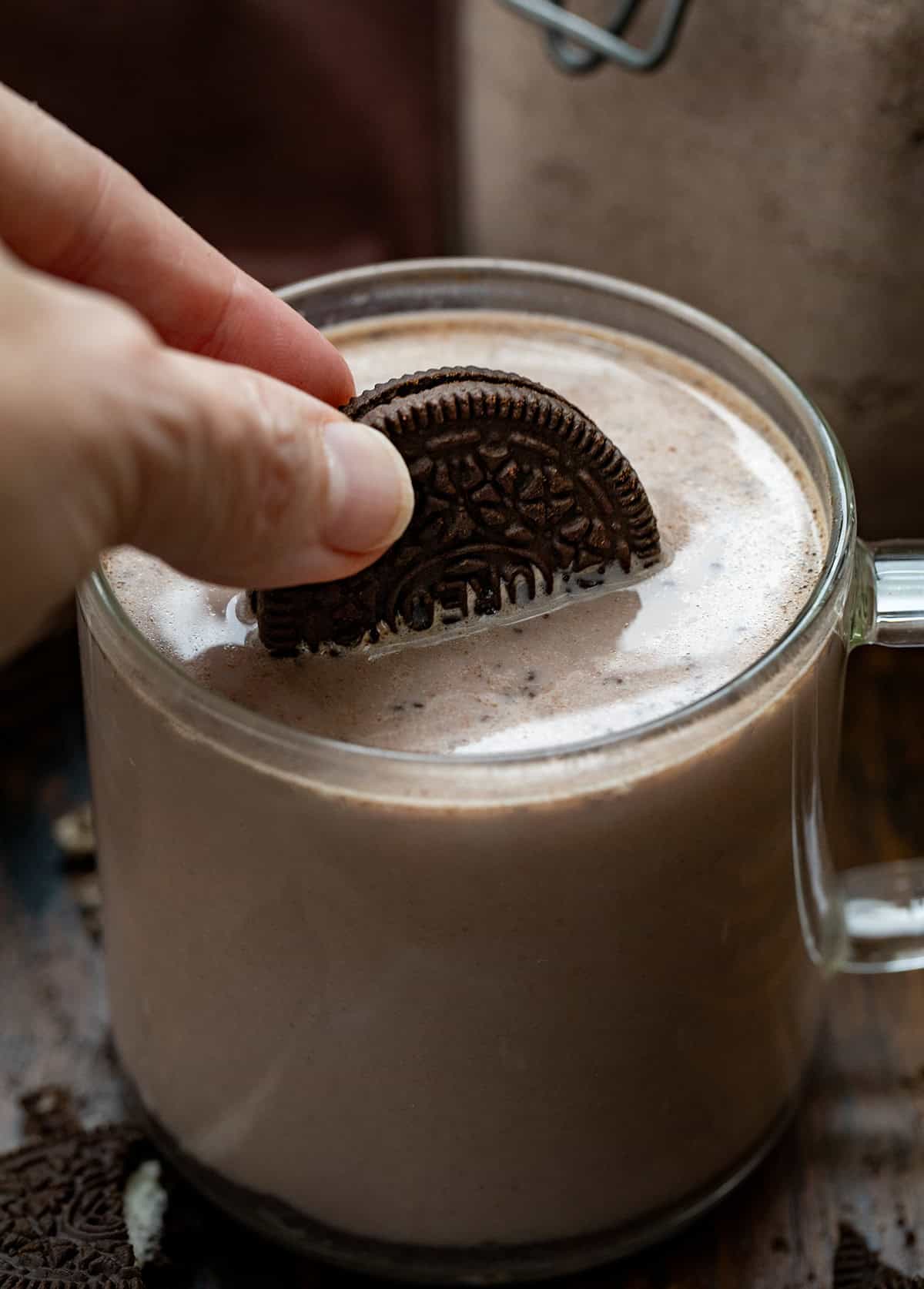 Dipping an Oreo into a hot mug of Cookies & Cream Hot Cocoa Mix.