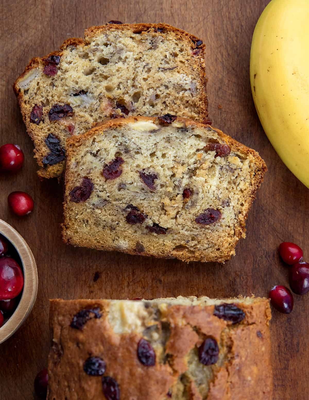Loaf of Cranberry Banana Bread from overhead that has a few slices cut and laying flat.