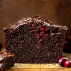 Looking straight on at a loaf of Cranberry Brownie Bread that has been cut into showing the inside texture.