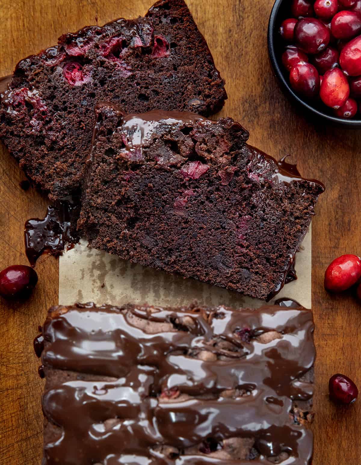 Loaf of Cranberry Brownie Bread with a couple of pieces cut and laying flat from overhead.