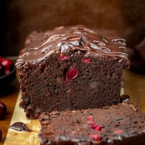 Loaf of cut into Cranberry Brownie Bread showing tender texture inside.