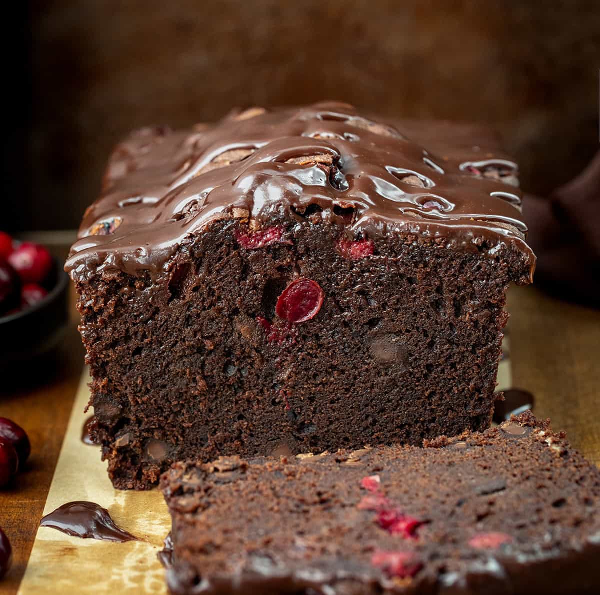 Loaf of cut into Cranberry Brownie Bread showing tender texture inside.