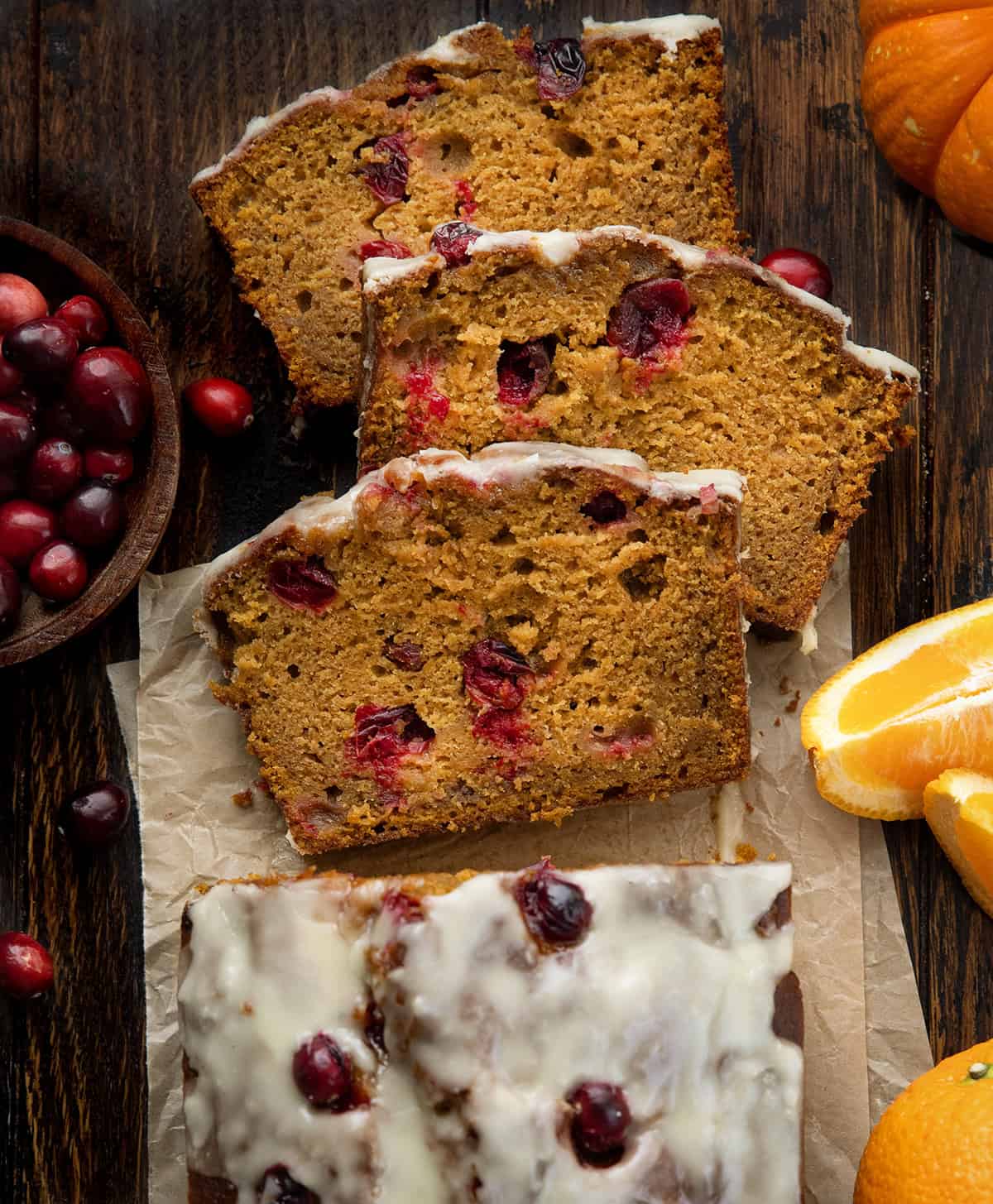 Looking down on a loaf of Cranberry Orange Pumpkin Bread with a few slices cut and laying flat Looking down on a loaf of Cranberry Orange Pumpkin Bread with a few slices cut and laying flat.