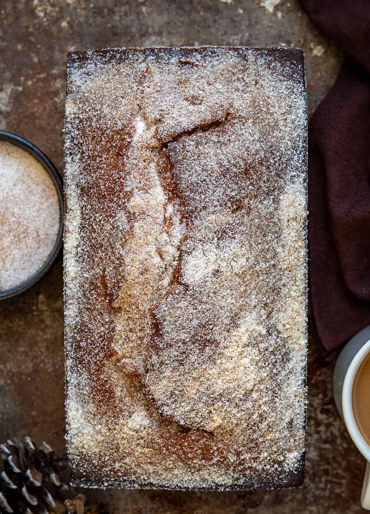 Loaf of Gingerbread Donut Bread next to coffee and nutmeg sugar from overhead Loaf of Gingerbread Donut Bread next to coffee and nutmeg sugar from overhead.