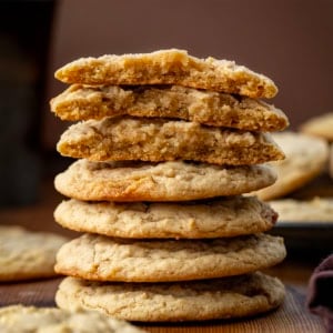 Stack of Maple Cookies with the top cookies broken showing inside texture on a wooden table.