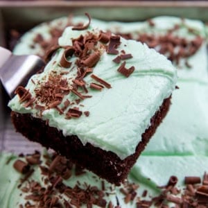 Spatula picking up a piece of Mint Chocolate Sheet Cake from the sheet pan.
