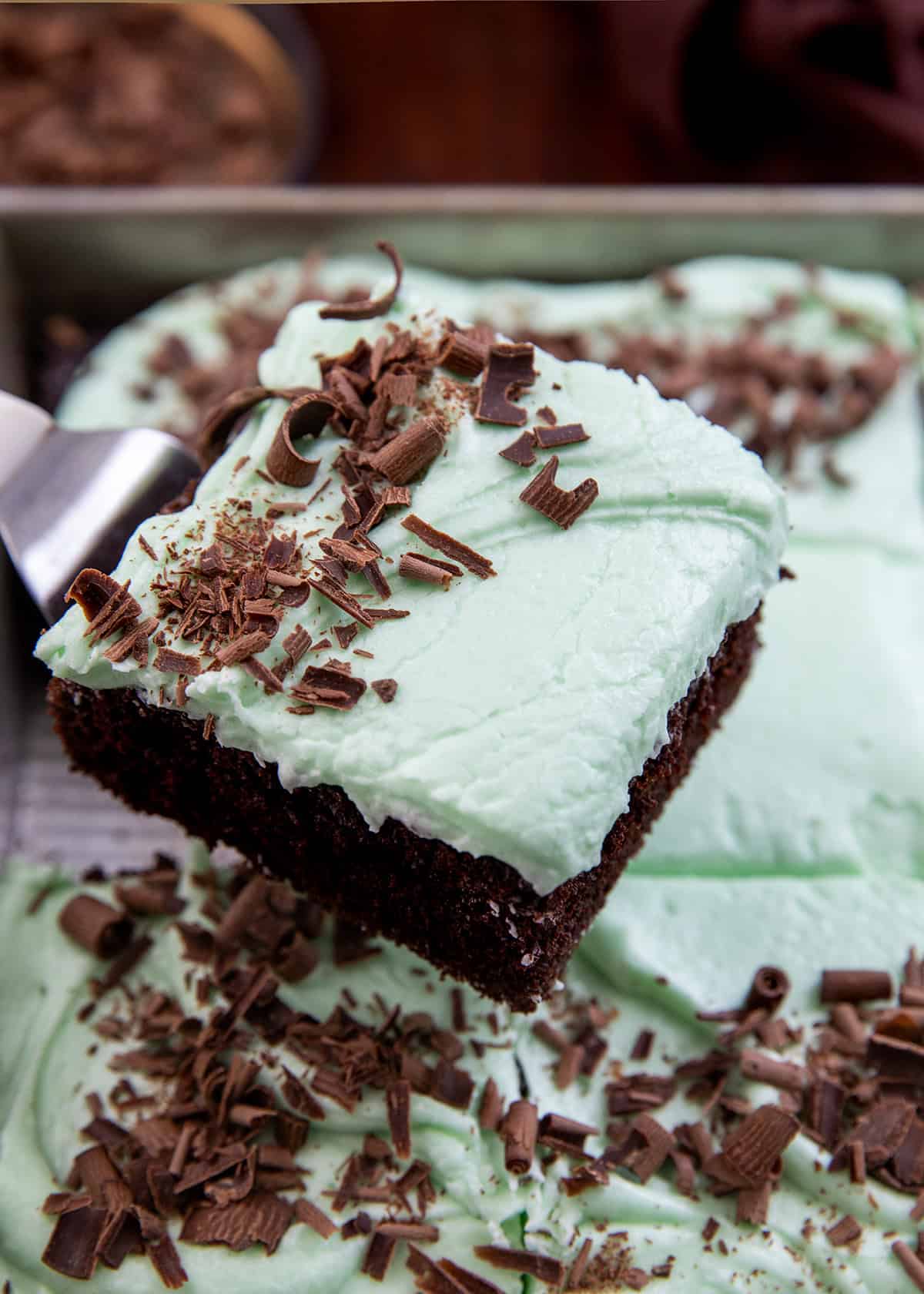 Spatula picking up a piece of Mint Chocolate Sheet Cake from the sheet pan.