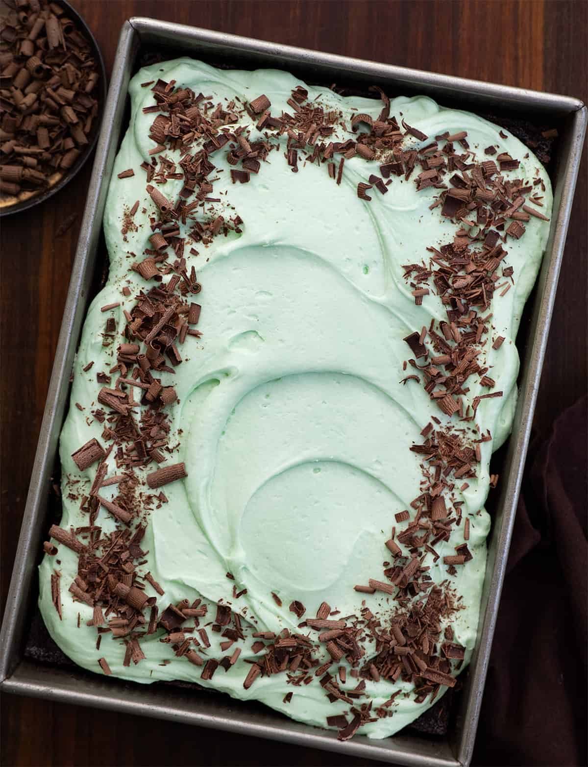 Mint Chocolate Sheet Cake in the pan on a wooden table from overhead.