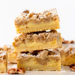 Close up of a stack of Pecan Vanilla Cream Crumb Bars on a white table.