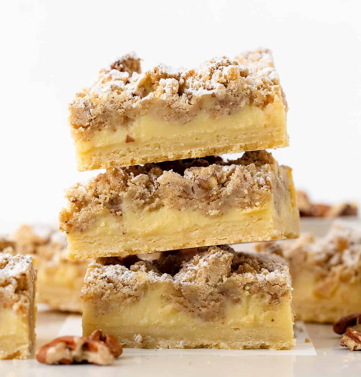 Close up of a stack of Pecan Vanilla Cream Crumb Bars on a white table.