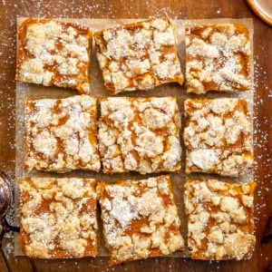 Pumpkin Cream Crumb Bars cut into squares on a wooden table from overhead.